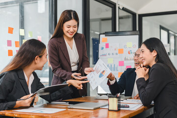Professional women collaborating in modern office, sharing ideas and discussing reports. Their expressions reflect engagement and teamwork, showcasing productive meeting