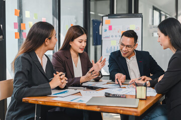 Collaborative business meeting with diverse professionals discussing strategies and analyzing data. Engaged expressions and teamwork highlight productive atmosphere