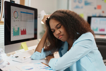 Tired manager touching her head, having a headache while analyzing financial charts, feeling...