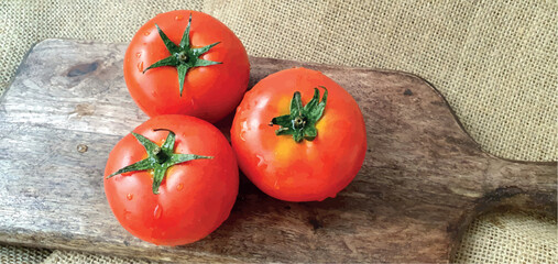 Ripe tomatoes on a wooden board close-up. Juicy tomatoes. Red tomatoes on the table. Fresh tomatoes for cooking. Tomato vegetable. Cooking and recipes.