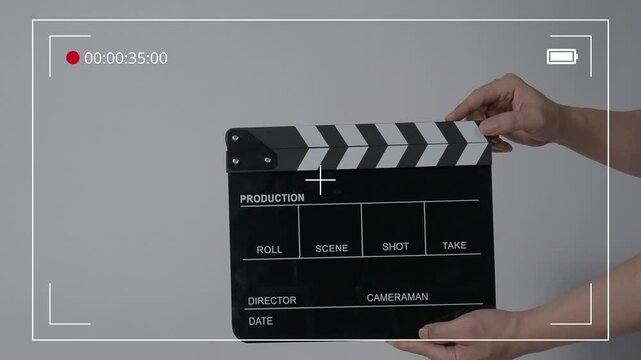 Movie slate or clapperboard hitting with recording frame. Close up hand holding empty film slate and clapping in front of camera clear background. Open and close film slate filming a video production
