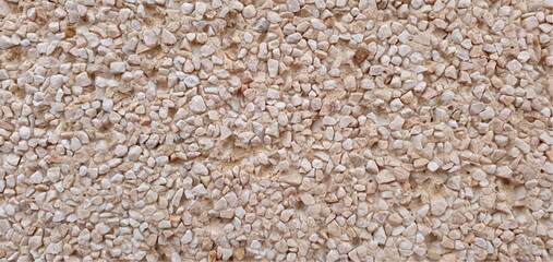 Stone background made of small stones, stone texture. Texture of stone wall, stone tiles, stonework background. Interior and exterior design, facade, fence. Building materials, repairs, construction.