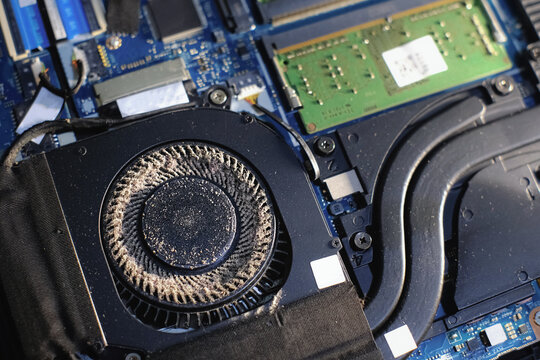 Dust on laptop fan. Maintaining computer for efficiency. Electronic service repair. Dusty inside cooling system