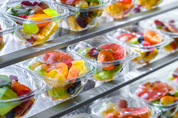 Boxes with pre-packaged fruit salads in a commercial fridge