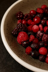 A ceramic bowl filled with frozen mixed berries