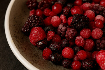 A ceramic bowl filled with frozen mixed berries