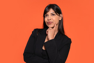 Contemplating a bright future in front of a vibrant orange backdrop at a creative studio