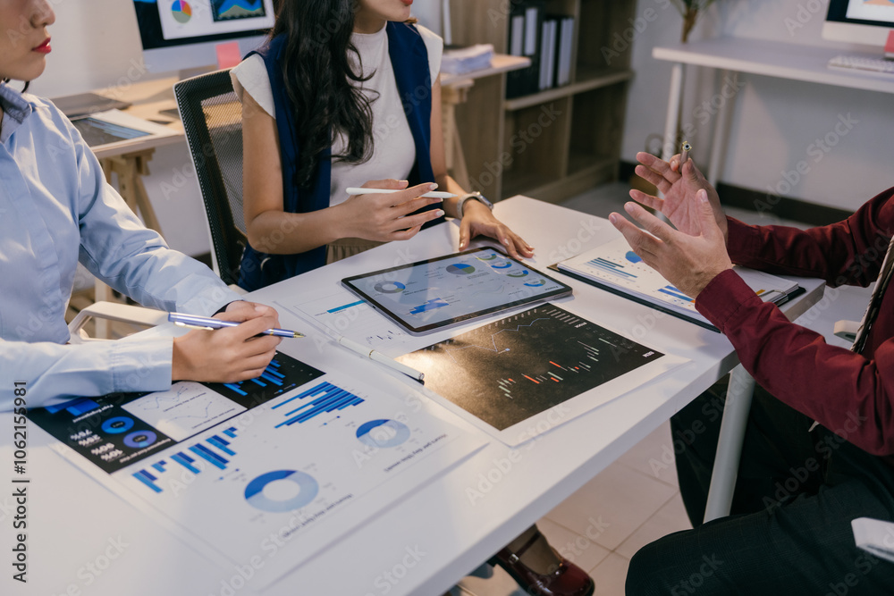 Poster Business team analyzing charts and graphs displayed on a digital tablet and printed documents, collaborating on data interpretation and strategic decision-making during an office meeting