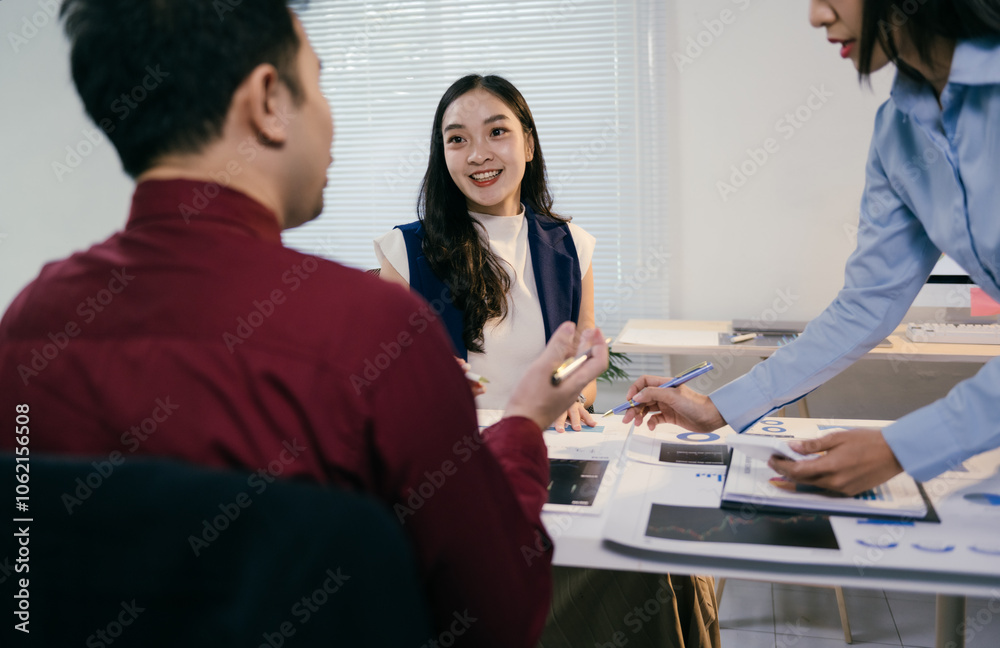 Poster Asian business team analyzing financial data and discussing charts and graphs during a meeting in a modern office, demonstrating collaboration and strategic planning