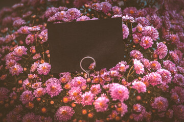 Tafel in schwarz zum Beschreiben zwischen Blumen in pink rosa rot