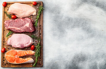 Mix of raw meat and fish . Salmon , beef , pork , chicken staek . Top view