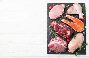 Mix of raw meat and fish . Salmon , beef , pork , chicken staek . Top view