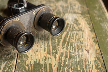 Metal binoculars on a wooden military box. Vintage old optics.