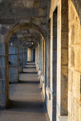 Ancient Stone Corridor with Arched Passageway at Dusk