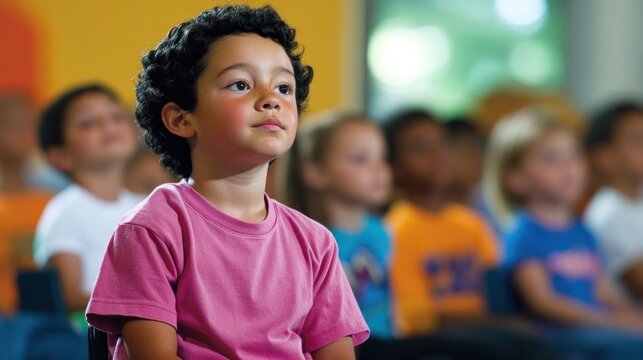 A boy sits quietly in a vibrant classroom, focused on the activity as his classmates gather around him, all participating in an enriching educational experience together