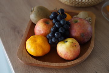 Various fruits on a wooden bowl.
