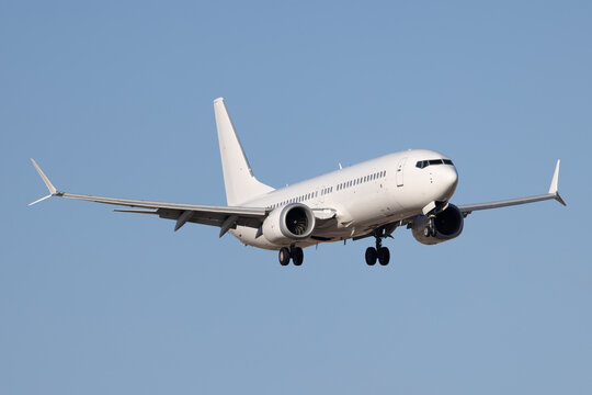 White modern airliner landing at airport.