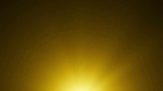 Bright golden orb growing and glowing like a rising sun as it surfaces from the bottom centre of frame before reaching a powerful crescendo then fading away again