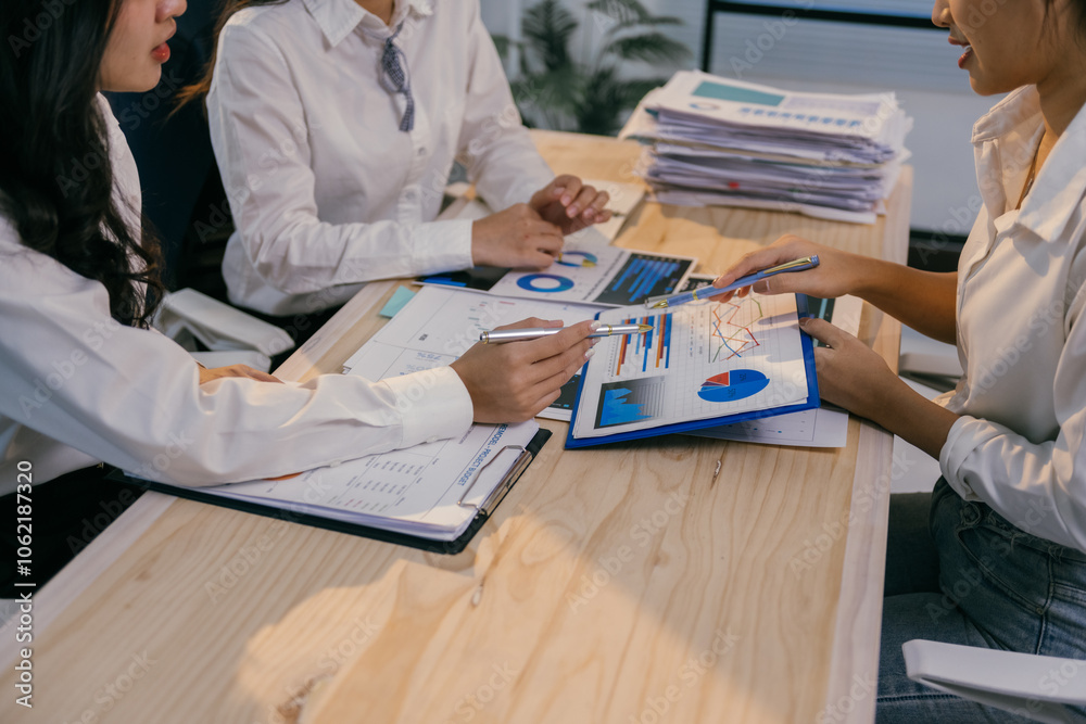 Aufkleber businesswomen in white shirts are sitting at wooden office desk analyzing financial charts and graph