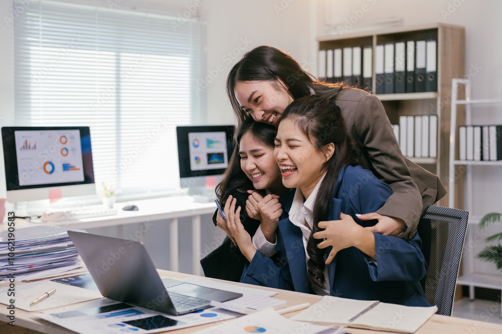 Poster three cheerful businesswomen are embracing and laughing while working together on a project in a mod