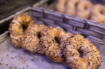 A large bunch of delicious bagels is sitting on a tray on a table