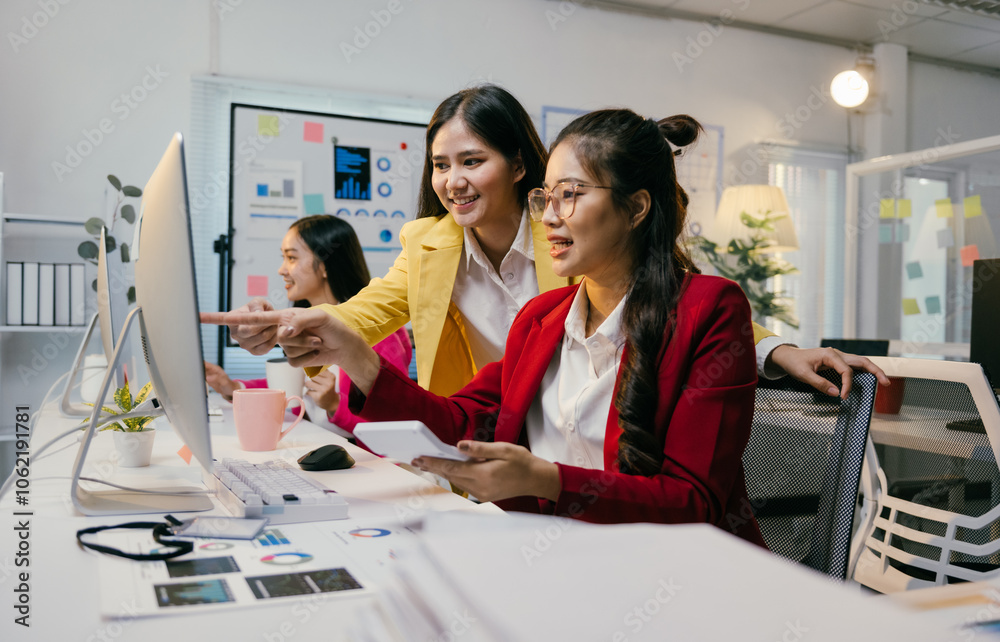Poster Asian businesswomen are collaborating on a computer, analyzing charts and using a calculator in a modern office, demonstrating teamwork and data analysis