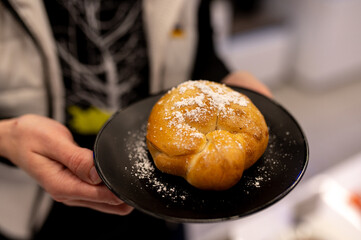 A Delicious and Appetizing Pastry Dusting with Sugar Serving on a Beautiful Black Plate