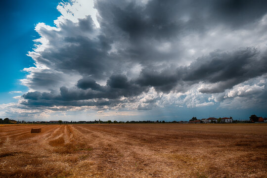 Dramatic skyscape over a wheat field after harvesting wheat, San Giuliano Vecchio, Alessandria, Piedmont, Italy