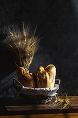 Fresh bread with ear of wheat. Dark still life.