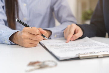 Financial, asian woman lease landlord, agent banker or bonding hand is pointing to contract of tenant, new owner or renter of home to sign signature on purchase, rental property. Estate mortgage.