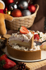 Rustic strawberry meringue tart with a crumbly cookie crust, topped with crushed meringue and fresh strawberries, set in a festive holiday setting with pinecones and Christmas ornaments.