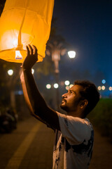 man releasing a glowing sky lantern at night, capturing the festive spirit of Diwali, symbolizing hope, light, and the triumph of good over evil. Ideal for themes of Diwali, celebration, and cultural 
