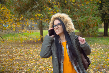 A young, beautiful girl travels in nature, admires the beauty of the autumn forest with admiration,...