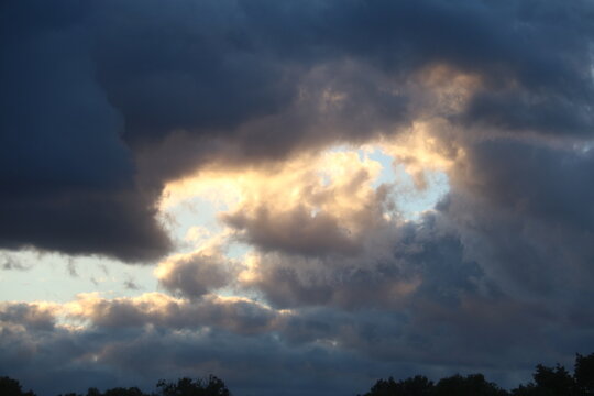 Nubes grises y blancas del atardecer, los &uacute;ltimos rayos de sol iluminan los bordes o comisuras de las nubes d&aacute;ndoles un tono c&aacute;lido y permitiendo la entrada de la luz natural
