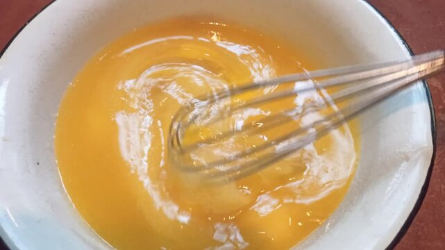 Proccess of making shortbread dough for a pie, mixing  eggs and suger  with a whisk. Horizontal 4k footage. Baking