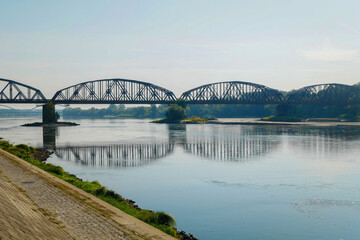 Old railroad bridge, on the Vistula River .On the left along the bank is an embankment with lanterns.