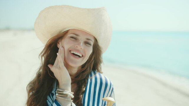 happy modern female on the beach with sunscreen.