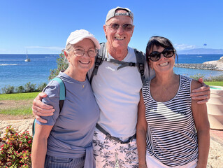 Group of three seniors smiling people outdoors with sea view on background Enjoying Vacation and Freedom in a sunny day. Happy Retirement Lifestyle Concept