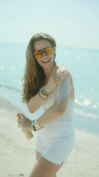 happy elegant woman on the beach with spf.