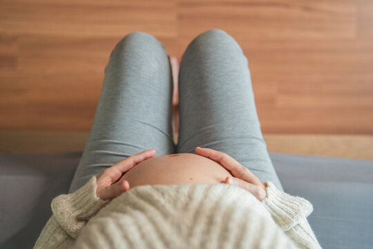 Top view - pregnant woman with belly, Woman with big bare a belly stroking the belly, Health pregnancy motherhood procreation concept.