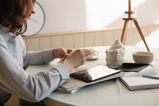 Close-up of a woman sitting at a dining table working from home