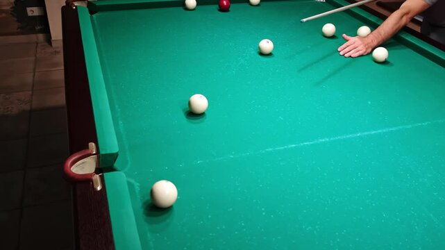 Playing Russian billiards on a green table. Billiard player hitting white cue ball missing the shot. Bad hit. Unsuccessful attempt. A failure game. Hobby pastime. Middle pocket. 4K