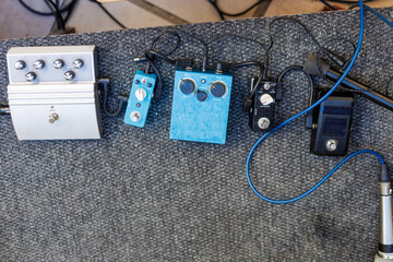 Various guitar effects pedals arranged on a performance stage floor