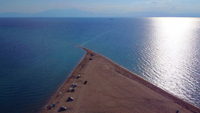 Sunlit sandbar reaching into the aegean sea at Epanomi, Greece