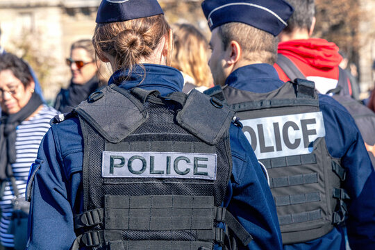 Two policemen, a man and a woman, wearing bulletproof vest with the word police on them