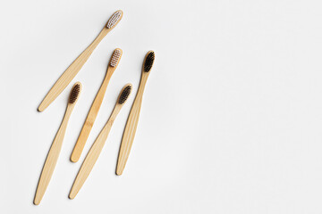 Top view of eco-friendly bamboo toothbrushes arranged on grey white background, emphasizing sustainability and minimalism, Natural organic bathroom beauty product concept, dental .hygiene, flat lay