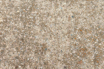 Concrete texture. Pebbles of different colors and signs of aging are visible.