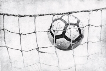 Black and white image of a soccer ball caught in a net illustrating motion and tension in a classic sports scene

