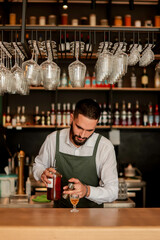 Skilled bartender prepares a cocktail at a stylish bar during a vibrant evening in a bustling city