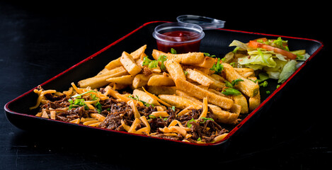 American fast food - beef with cheese, French fries and salad with ketchup